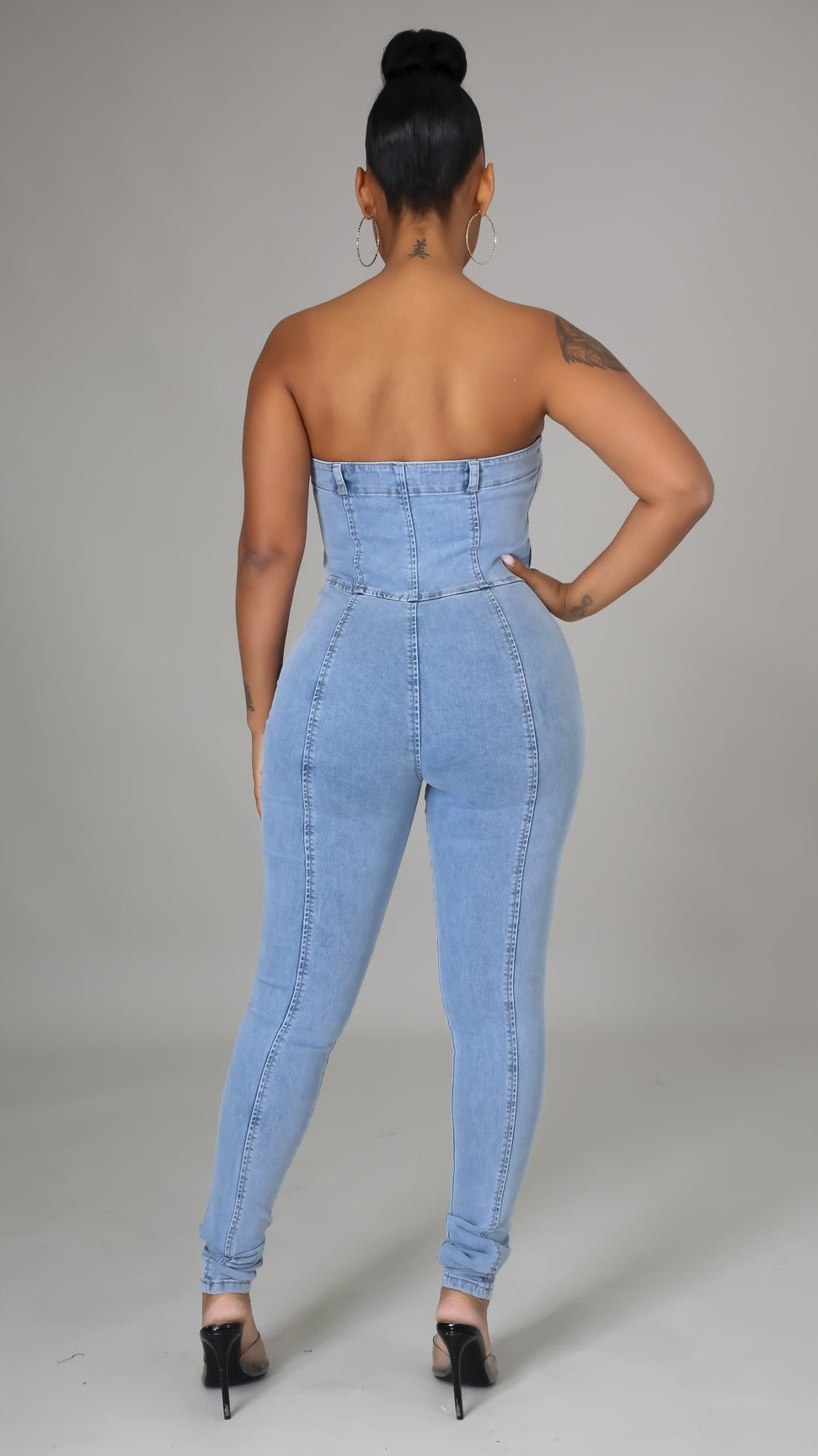 une combinaison bustier en denim qui allie sophistication et sensualité. Coupée dans un jean slim