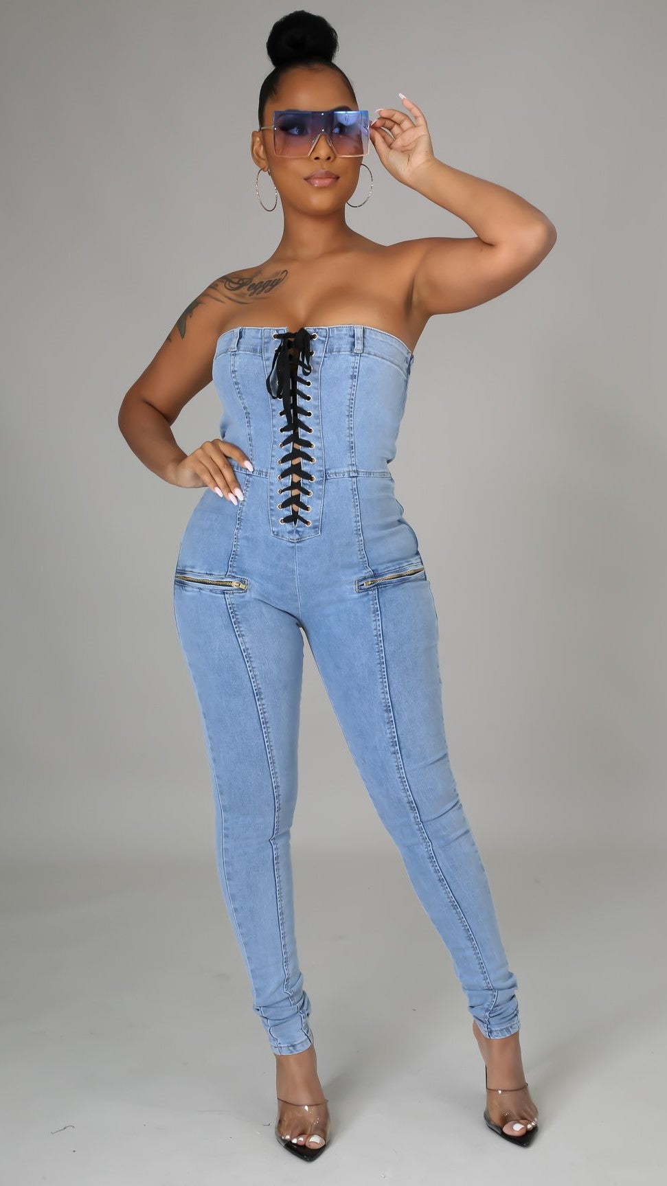 une combinaison bustier en denim qui allie sophistication et sensualité. Coupée dans un jean slim